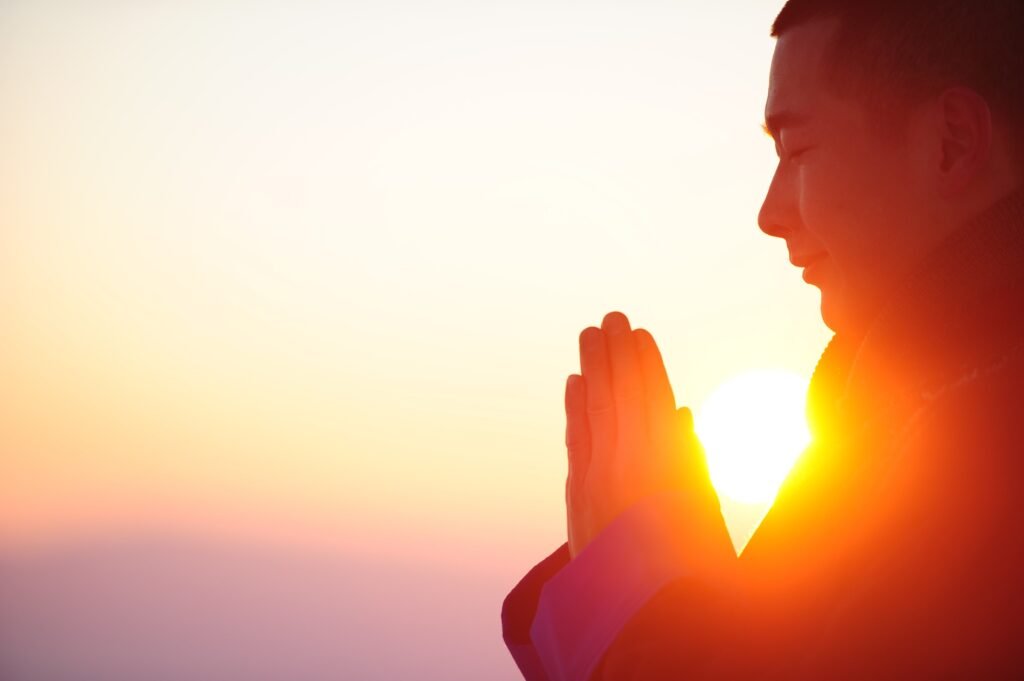 Person meditating outdoors at sunrise for mental wellness strategies 2025.
